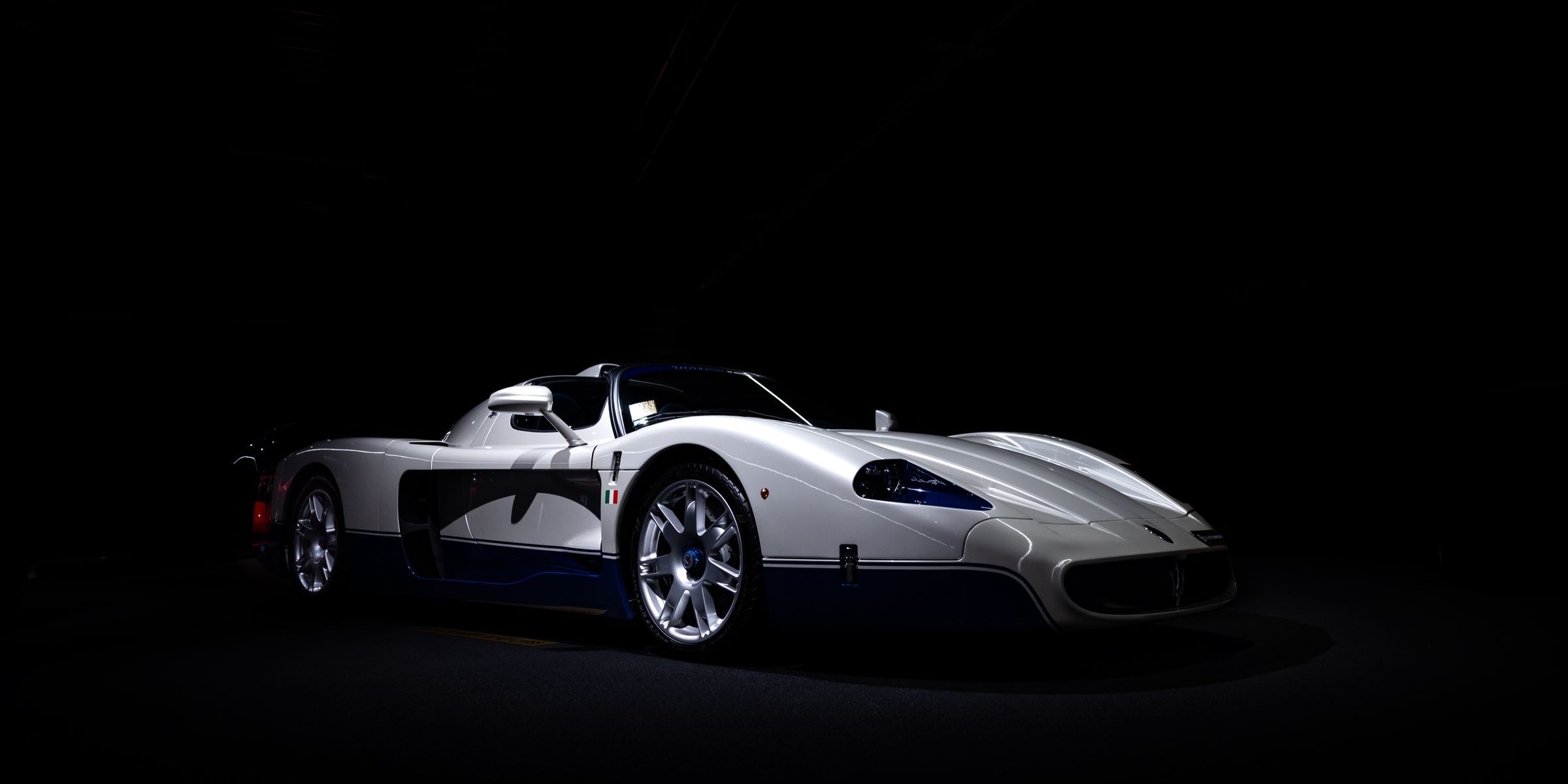 White sports car lit against a dark background
