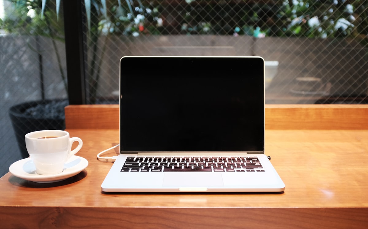 Laptop and coffee on a wooden desk