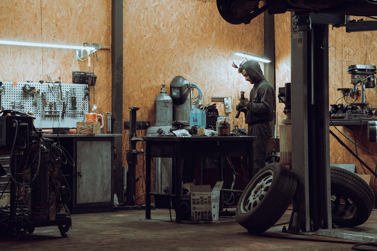Workshop interior, mechanic working, tools and tyres